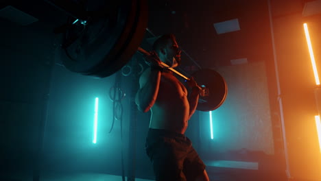 brawny-powerlifter-is-training-in-gym-lifting-barbell-in-dark-hall-endurance-and-motivation